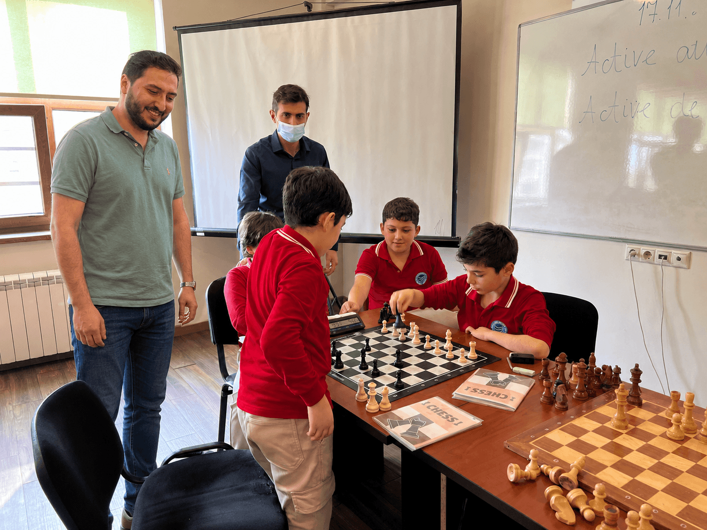 Emin coaching students at a school chess club